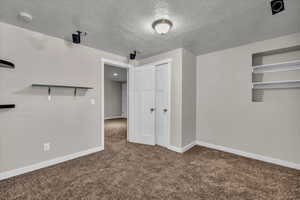 Additional living space with carpet and a textured ceiling