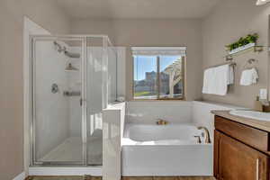 Bathroom featuring vanity, tile patterned floors, and plus walk in shower