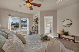 Bedroom featuring ensuite bathroom, ceiling fan, cooling unit, and carpet flooring