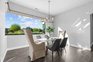 Dining area featuring dark wood-type flooring and an inviting chandelier