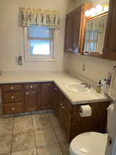 Bathroom featuring toilet, vanity, and tile patterned floors