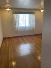 Bedroom  with hardwood / wood-style flooring and a textured ceiling