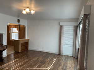 Living room featuring dark wood-type flooring and crown molding