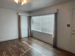 Front room featuring dark hardwood / wood-style flooring, a notable chandelier, and crown molding