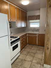 Kitchen featuring white appliances and sink