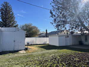 View of yard featuring a storage shed and a patio area