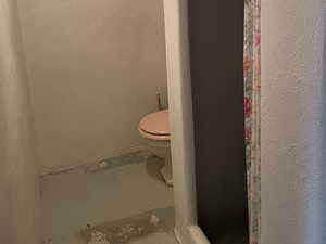 Bathroom with toilet and concrete floors