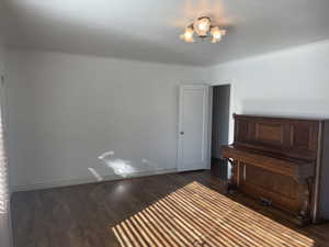 Living room featuring an inviting chandelier, dark hardwood / wood-style flooring, and ornamental molding