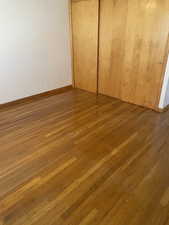 Bedroom with wood flooring and a closet