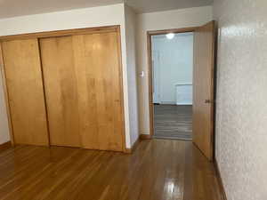 Bedroom with wood flooring and a closet