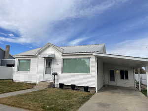 View of front of property with a front lawn and a carport