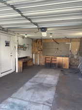 Garage featuring a garage door opener and a workshop area