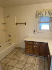 Bathroom featuring tile patterned flooring, vanity, and shower / bath combination