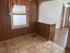 Dining area with light hardwood / wood-style floors and wood walls