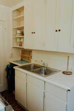 Kitchen featuring white cabinetry and sink