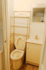 Bathroom with hardwood / wood-style floors, vanity, and toilet