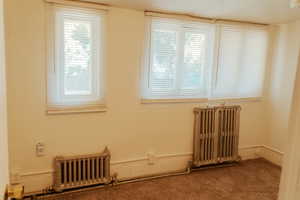 Carpeted empty room with radiator heating unit