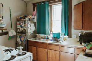 Kitchen with sink, white stove, and stainless steel fridge