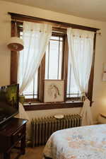 Bedroom with carpet floors and radiator