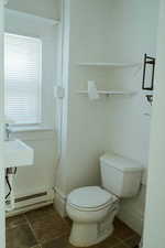 Bathroom with a baseboard radiator, sink, and toilet