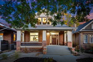 View of front facade with porch and xeriscaped front lawn. Sound dampening windows on front facade