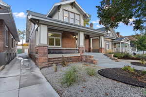 View of front facade with porch and xeriscaped front lawn. Sound dampening windows on front facade