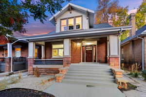 View of front facade with porch and xeriscaped front lawn. Sound dampening windows on front facade