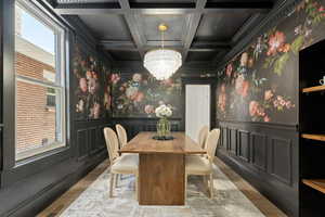 Dining room with Graham & Brown Wallpaper, Crystal Chandelier, Coffered Ceiling, Wainscoting, and open shelving