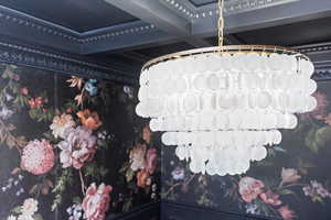 Dining room with Graham & Brown Wallpaper, Crystal Chandelier, Coffered Ceiling, Wainscoting, and open shelving