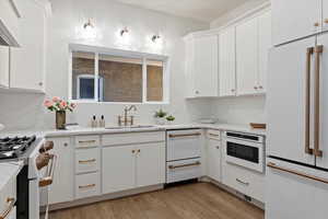 Kitchen Area with Cafe appliances, double drawer dishwasher, quartz countertops with full backsplash, pot filler, Custom cabinets in custom color, Solid brass faucets, and exquisite lighting.