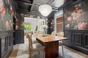 Dining room with Graham & Brown Wallpaper, Crystal Chandelier, Coffered Ceiling, Wainscoting, and open shelving