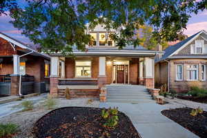 View of front facade with porch and xeriscaped front lawn. Sound dampening windows on front facade