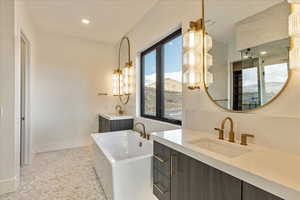 Bathroom with a washtub, vanity, decorative backsplash, and a mountain view