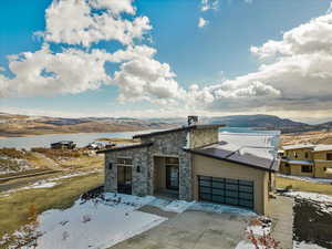 View of front of property featuring a water and mountain view and a garage