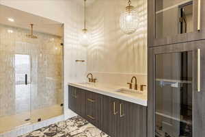 Bathroom with walk in shower, vanity, and tile walls