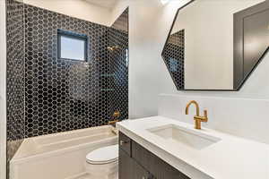 Full bathroom featuring vanity, toilet, and tiled shower / bath combo