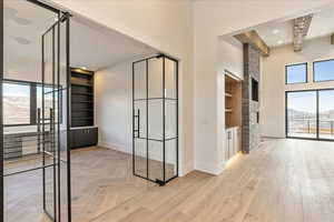 Corridor with a mountain view, light hardwood / wood-style floors, and beam ceiling