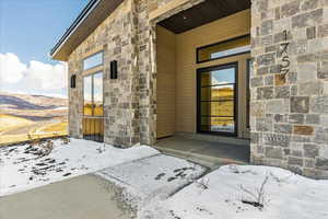 Snow covered property entrance featuring a mountain view