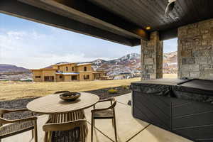 View of patio featuring a hot tub and a mountain view