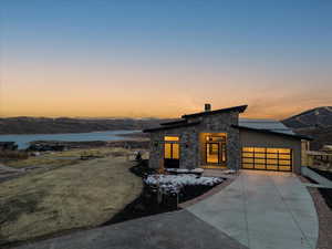 View of front of house with a garage and a water and mountain view