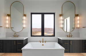 Bathroom with a bathtub, vanity, and a mountain view