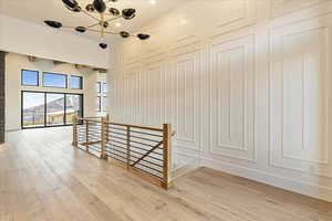 Staircase with hardwood / wood-style flooring and a notable chandelier