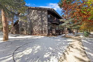 End unit with covered deck looking onto pines