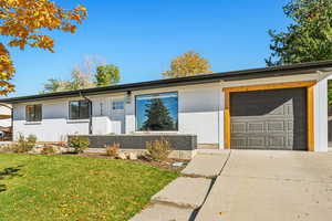 Single story home with a garage and a front yard