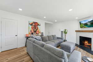 Living room featuring a high end fireplace and light hardwood / wood-style flooring