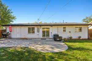 Rear view of property with a patio and a yard