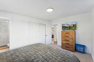 Bedroom featuring ensuite bath, a closet, and carpet