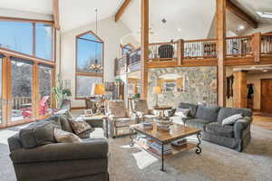 Living room featuring beam ceiling, high vaulted ceiling, and carpet