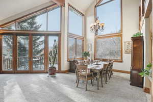 Sunroom with a chandelier, a healthy amount of sunlight, french doors, and vaulted ceiling