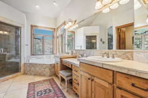 Bathroom with vanity, independent shower and bath, tile patterned floors, and lofted ceiling